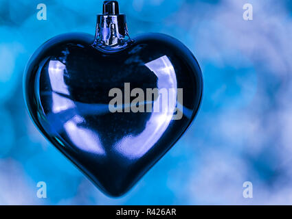 Bellissime decorazioni di Natale a forma di cuore sulla texture blu in primo piano. Foto Stock