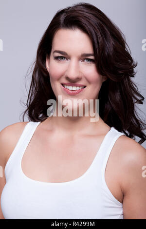 Attraente ridere giovane donna con lunghi capelli scuri Foto Stock