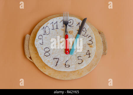 Un orologio fatto di piadina segna la pausa pranzo Foto Stock