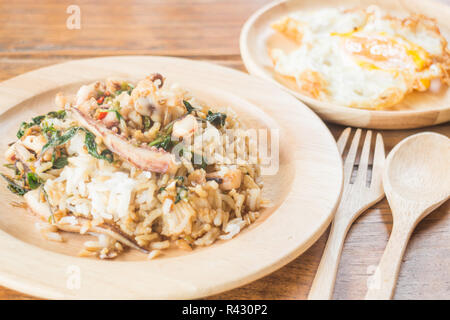 Il riso condito con stir-calamari fritti e basilico uovo fritto (cibo tailandese) Foto Stock