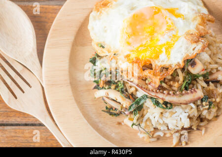 Il riso condito con stir-calamari fritti e basilico uovo fritto (cibo tailandese) Foto Stock