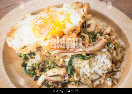 Il riso condito con stir-calamari fritti e basilico uovo fritto (cibo tailandese) Foto Stock