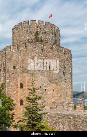 Vista di una torre fortificata nel Rumeli fortezza, Istanbul, Turchia, con il ponte Fatih in background. Foto Stock