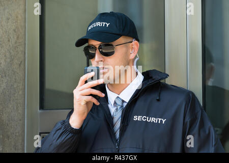 La guardia di sicurezza utilizzando un walkie-talkie Radio Foto Stock