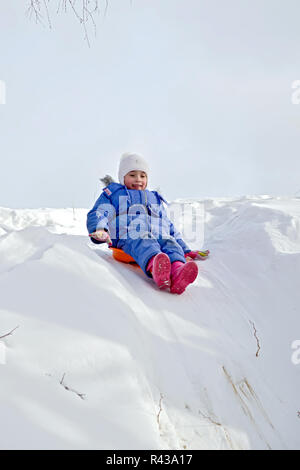 Bambina rotolamento su una collina Foto Stock