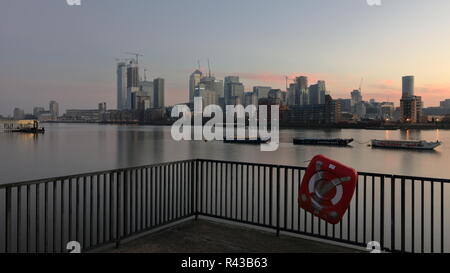 La mattina presto sul lato della Groenlandia accanto alla Marina Sud Dock con una bella vista al Canary Wharf area. Riverside acqua tranquilla con bella riflessioni. Foto Stock