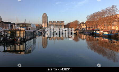 La mattina presto in Sud Dock area marina a Londra con barche parcheggiate e bella riflessioni sull'acqua. Pulire e il cielo sereno, verso la fine di novembre. Foto Stock