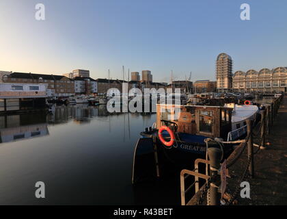 La mattina presto in Sud Dock area marina a Londra con barche parcheggiate e bella riflessioni sull'acqua. Pulire e il cielo sereno, verso la fine di novembre. Foto Stock