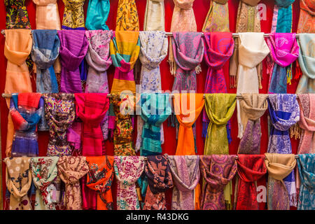 Foulard colorati sul display in rack in un bazar. Foto Stock