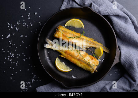 Vista dall'alto di due pesci smelleds in padella con il limone Foto Stock