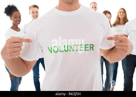 Felice l'uomo che mostra il testo di volontariato su Tshirt Foto Stock