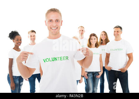 Felice l'uomo che mostra il testo di volontariato su Tshirt Foto Stock