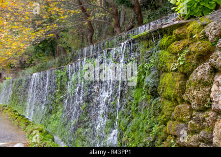 Vista delle cascate artificiali di un ruscello di montagna che scorre verso il basso su moss-coperta di pietre. La Grecia Foto Stock