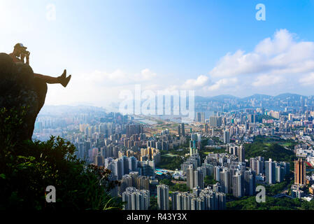 L'uomo prendendo la foto di un Hong Kong cityscape vista dal Lion rock Foto Stock