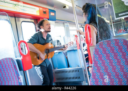 L uomo e la donna di eseguire un duetto su un treno diretto a Lisbona, Portogallo. Foto Stock