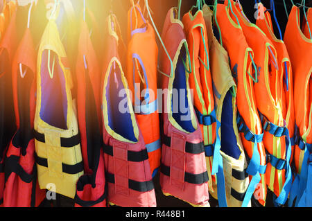 Giubbotti di salvataggio su portabiti / colorate di giubbotti di salvataggio Attrezzature di sicurezza appeso sulla barca Foto Stock