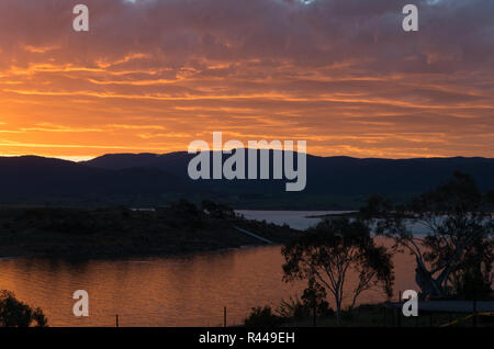 Vivace Lago Tramonto con elementi stagliano sopra il lago Jindabyne & MONTAGNA Foto Stock