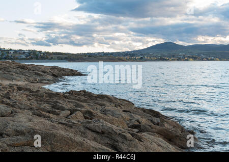 Tramonto sul lago Jindabyne & montagne innevate su un pomeriggio nuvoloso Foto Stock