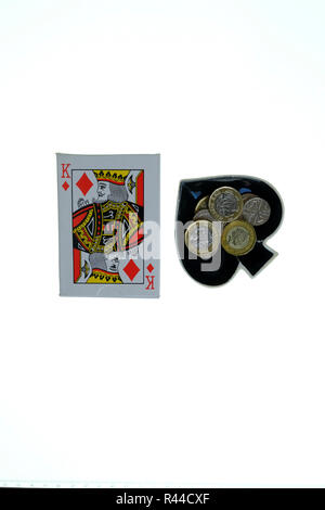 Pack di tradizionali carte da gioco su sfondo bianco con Ace of Spades gingillo a forma di ciotola per lato con cambio allentata in esso. Foto Stock