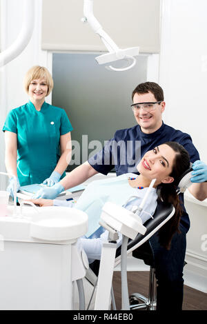 Paziente di sesso femminile con dentista e assistente Foto Stock