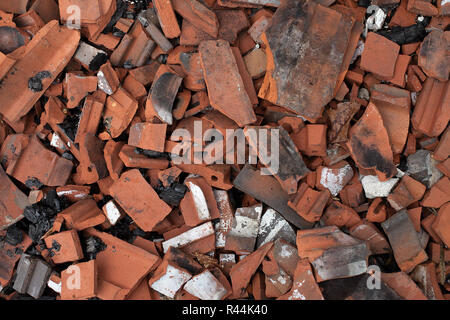 Rotture di piastrelle in terracotta dal tetto bruciato. Fracassato tegole del tetto, argilla tegole rosse. Destrucion del tetto. Foto Stock