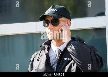 Giovani guardia di sicurezza in piedi di fronte all'entrata Foto Stock