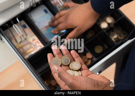 Persona della mano con Euro nota su contenitore Foto Stock