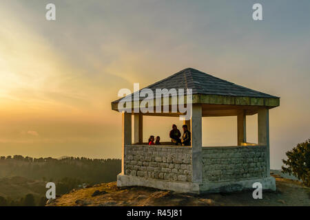 Lasciate che il mondo attesa- amici godendo/ riposo dopo la scalata verso la cima della collina/ mountain, godendo del tramonto, Dainkund Foto Stock