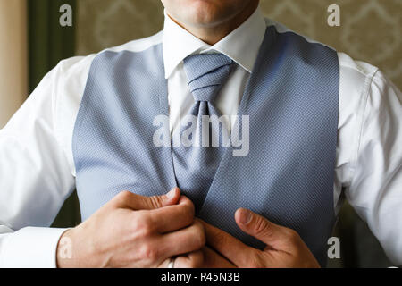 Un uomo mette su un costoso abito blu al mattino. Foto Stock