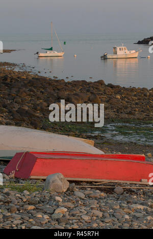 Le barche in acqua, skiffs sul litorale, spiaggia rocciosa. Red skiff. Segale si è trasformata in una ricca comunità di spiaggia sul New Hampshire costa, pesca. Foto Stock