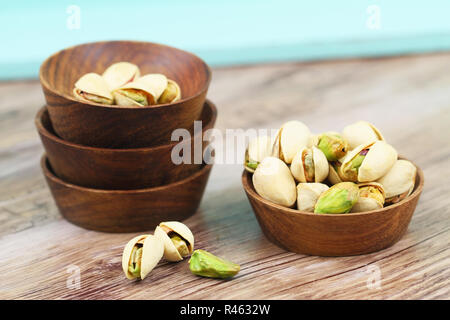 I pistacchi con e senza guscio in ciotole di legno Foto Stock