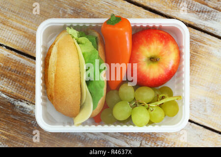 Scuola di sano pranzo contenente il rotolo di formaggio, frutta fresca e il peperone giallo Foto Stock