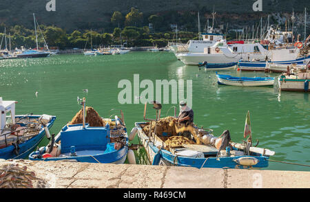 Pescatore che maneggia le sue reti nel porto di Marina chiamato Cala Marina di Castellammare del Golfo, Sicilia, Italia. Foto Stock