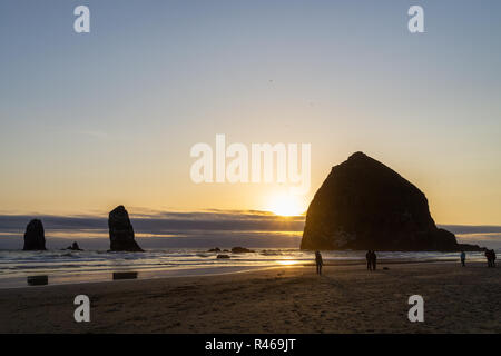 Il tramonto del Haystack Rock, monumento naturale della costa del Pacifico, Cannon Beach, Oregon, Stati Uniti d'America. Foto Stock