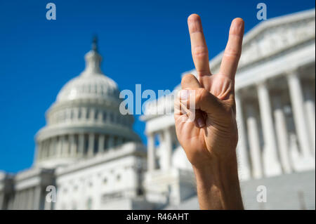 Mano di protestor tenendo in mano un segno di pace gesto di fronte al Campidoglio di Washington, DC, Stati Uniti d'America Foto Stock