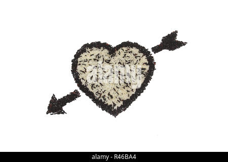 Forma di cuore e la freccia dal mix di riso bianco e il riso nero su sfondo bianco Foto Stock