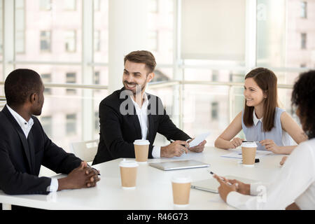 Sorridente friendly diversi colleghi parlare di gruppo seduta a mee Foto Stock