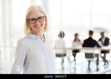 Sorridente coppia attraente imprenditrice in bicchieri cercando in ca Foto Stock