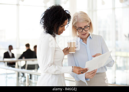 Senior Executive femmina discutendo di relazione con i giovani razza mista Foto Stock