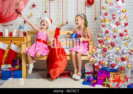 Due ragazze del divertimento e felice Anno Nuovo doni da Santa Claus in borsa Foto Stock