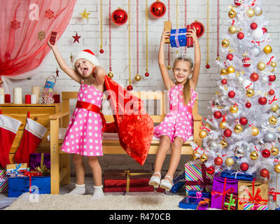 Due ragazze del divertimento e felice Anno Nuovo doni in un atmosfera famigliare del nuovo anno Foto Stock