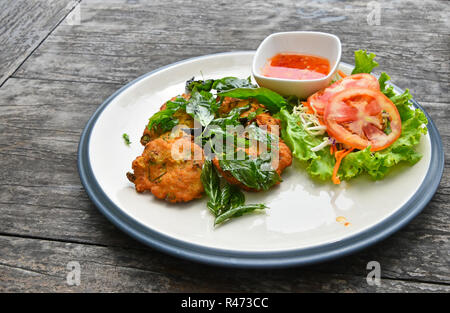 Piastra di gamberetti torte con insalata sul tavolo di legno Foto Stock