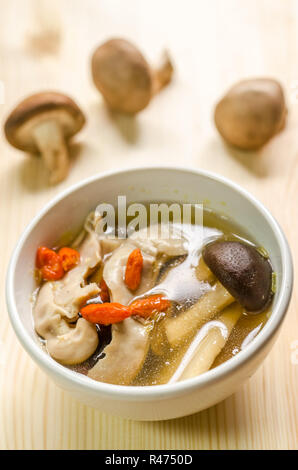 Vicino orientale tradizionale brodo di carne di maiale con funghi shiitake sul tavolo di legno Foto Stock