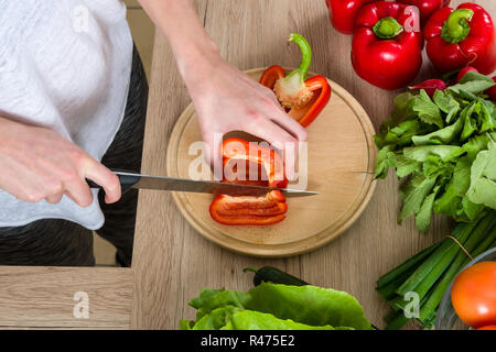 Donna in palestra suite tagliare le verdure in cucina, Bird view Foto Stock