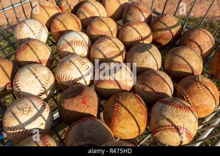 Close up molto utilizzato palle da baseball in cesto con erba sfondo sulla giornata di sole. Foto Stock