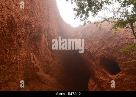 Parete erosa con fori della Cuevona nel Medulas romano ex miniera d'oro in un giorno con un sacco di nebbia in Medulas. Natura, viaggi, paesaggi, la sua Foto Stock