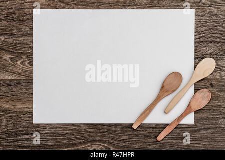 Cucchiai di legno sul Libro bianco e marrone di sfondo di legno Foto Stock