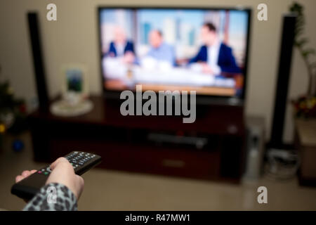 Tv e mano, premendo il telecomando Foto Stock