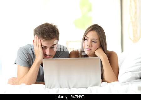 Annoiato matrimonio guardare i media in un computer portatile Foto Stock