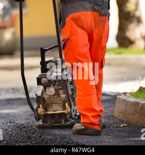 Rivestimento in asfalto il lavoro manuale. Foto Stock